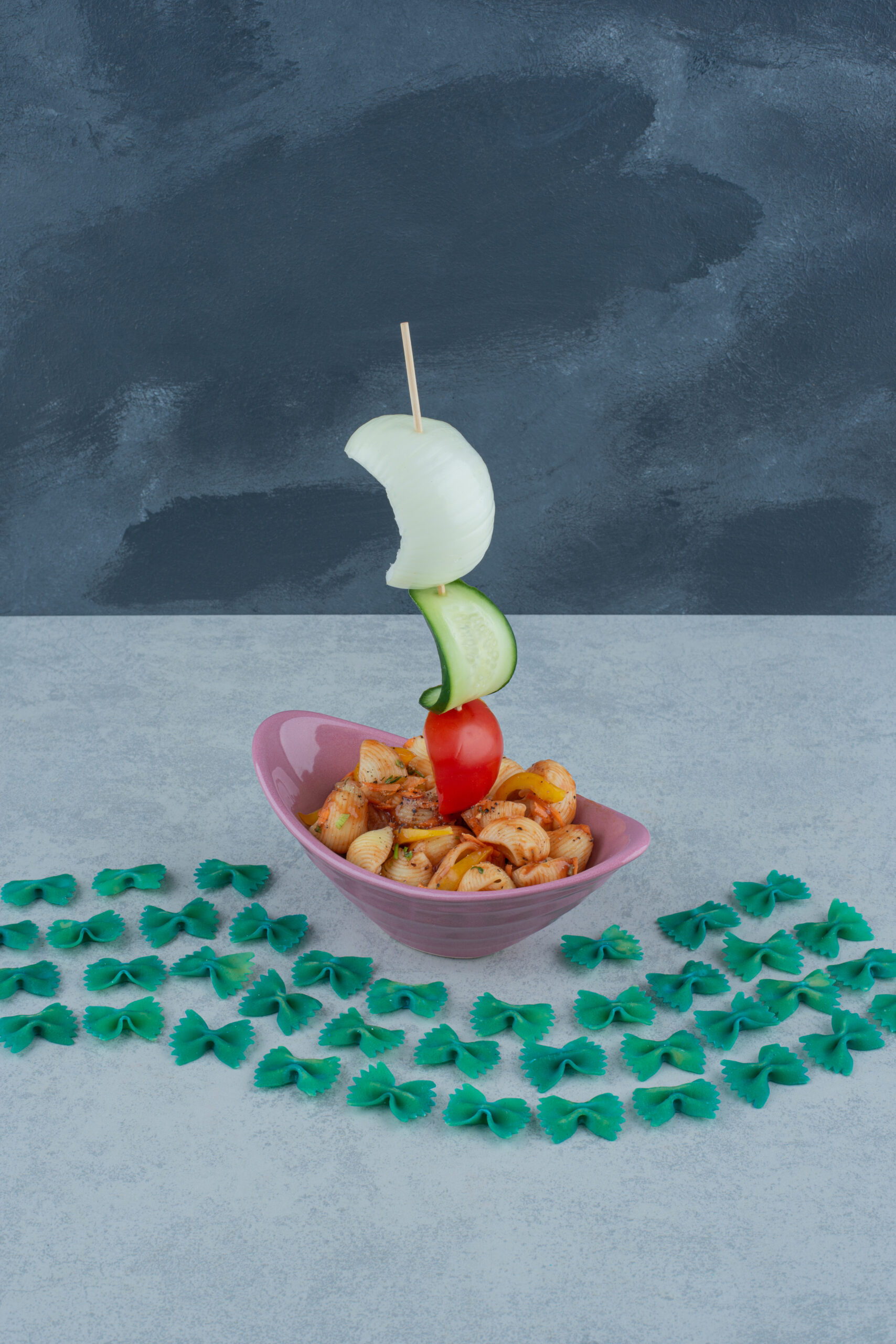 Delicious pink plate with macaroni on dark background. High quality photo